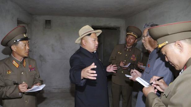 Kim Jong-un mit Hut bei einer Besichtigung mit Militärangehörigen.
