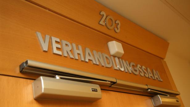 Die Tür zum Verhandlungssaal 203 mit einem automatischen Türschließer.