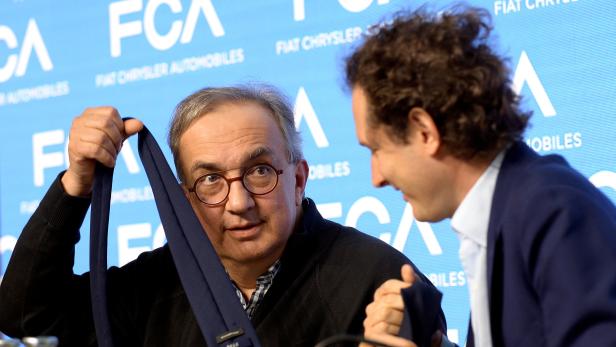 FILE PHOTO: Fiat Chrysler Automobiles CEO Sergio Marchionne jokes with a tie next to chairman John Elkann during media conference in Balocco