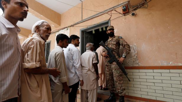 People line up at a polling station during the general election in Karachi