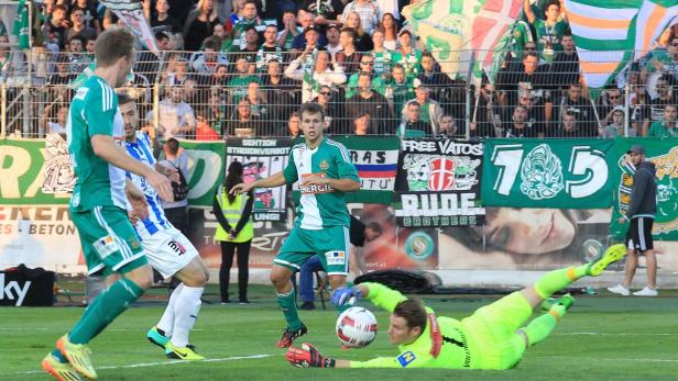 Ein Fußballspiel mit einem Torwart, der versucht, einen Ball zu halten, und Zuschauern im Hintergrund.