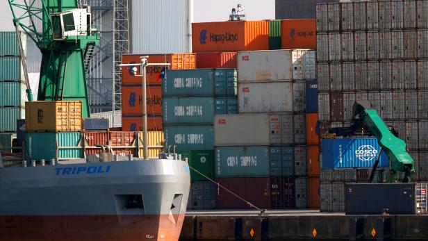 Ein Container der China Ocean Shipping Company wird im Hafen von Antwerpen auf ein Containerschiff verladen.