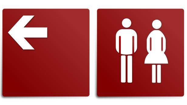 Schilder mit einem Pfeil nach links und einem Symbol für Damen- und Herrentoilette.