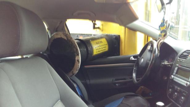 Innenansicht eines Autos, das auf einer gelben Fähre steht.