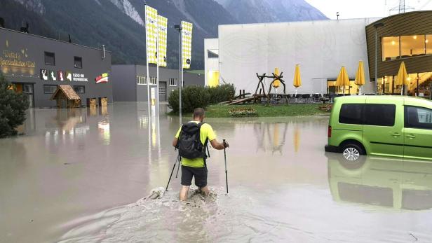 Überflutete Straße in Schnann in Tirol