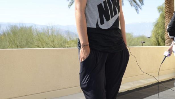 Maria Sharapova posiert im Sportoutfit vor Palmen und Bergen.