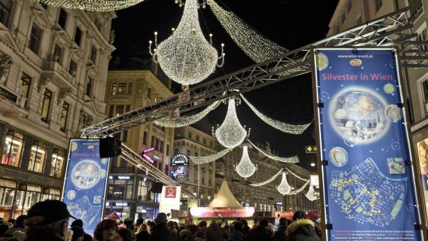 Die Silvesterfeierlichkeiten in Wien mit Menschenmassen und festlicher Beleuchtung.