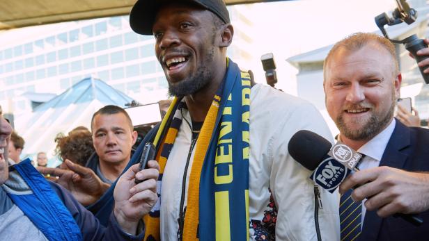 Eight-time Olympic champion Usain Bolt reacts as he arrives at Sydney Airport ahead of his trial at the Central Coast Mariners soccer club