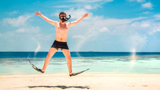 Funny man jumping in flippers and mask.