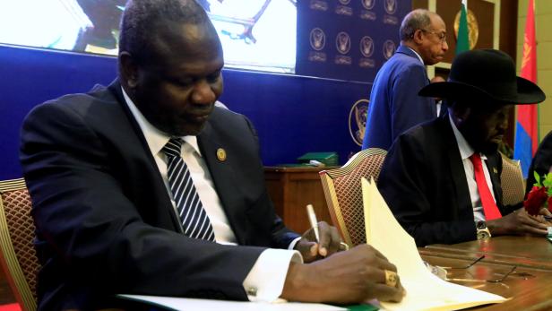 FILE PHOTO: South Sudanese rebel leader Riek Machar and South Sudan's President Salva Kiir sign a cease fire and power sharing agreement in Khartoum