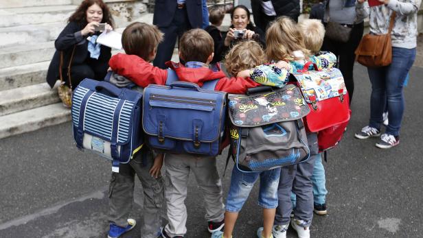 Schoolchildren pose for a group picture before entering the primary school Jules Ferry in Fontenay-sous-Bois near Paris on the start of the new school year in France