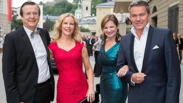 Eine Gruppe von zwei Paaren posiert für ein Foto vor einem Gebäude in Salzburg.