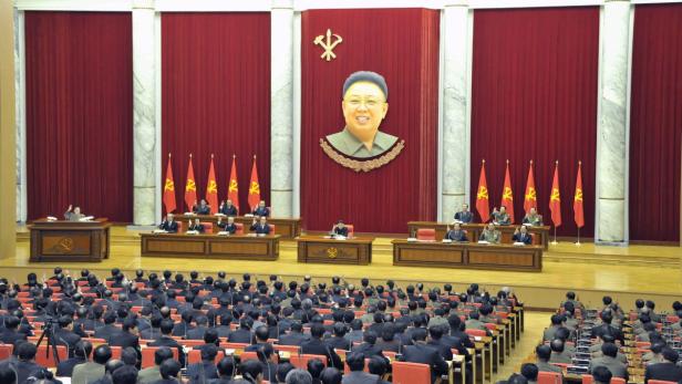 Eine Versammlung in Nordkorea vor einem Porträt von Kim Il-sung.