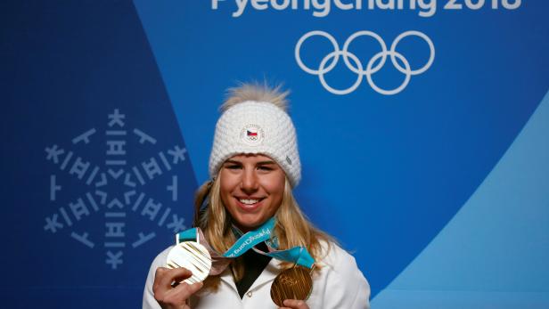 Gold medalist Ester Ledecka of the Czech Republic poses for photographs with her gold medals during a news conference in Pyeongchang
