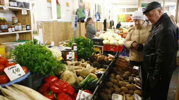 People shop in a market in Riga February 19, 2009. More and more farmers are starting to sell their products direct to the public in local markets in order to get a better price as their incomes have collapsed during the financial crisis. Farmers also want to avoid using the supermarket chains and food processors, which drive their prices down. REUTERS/Ints Kalnins (LATVIA)