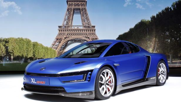 Ein blauer Volkswagen XL Sport vor dem Eiffelturm in Paris.