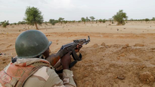 FILE PHOTO: A Niger soldier guards with his weapon pointed towards the border with neighbouring Nigeria, near the town of Diffa