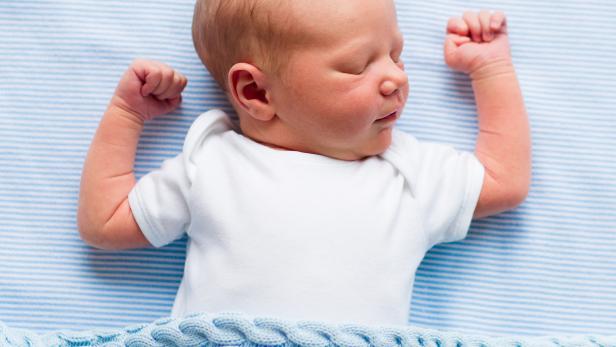 Newborn baby boy under a blue blanket