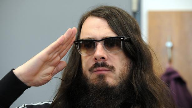 Ein Mann mit Bart und Sonnenbrille grüßt mit der Hand an der Stirn.