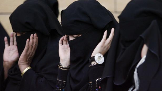 Mehrere verschleierte Frauen mit erhobenen Händen.