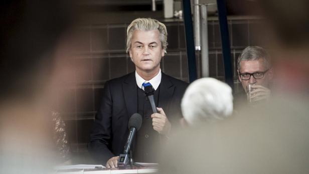 Geert Wilders spricht bei einer Veranstaltung vor Mikrofonen.