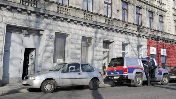 Ein Polizeibeamter steigt aus einem Polizeiwagen vor einem Gebäude.