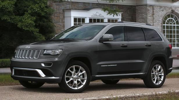 Ein grauer Jeep Grand Cherokee steht vor einem Haus.