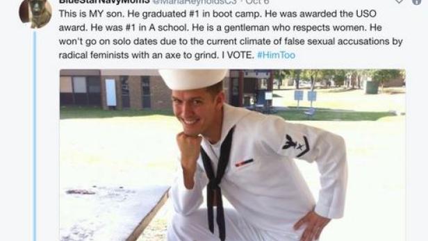 Ein junger Mann in Marineuniform posiert auf einer Picknickbank.