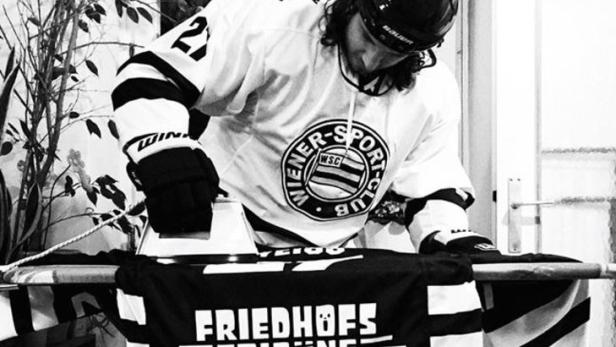 Ein Eishockeyspieler bügelt ein Trikot der „Friedhofs-Tribüne“.