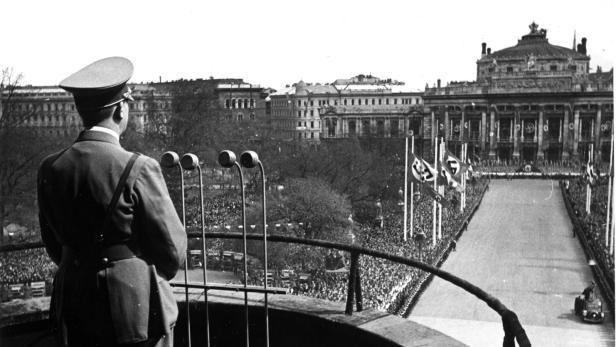 Vom beflaggten Burgtheater schallten Wagner-Klänge herüber: Adolf Hitler am 9. April 1938 auf dem für ihn errichteten Rathaus-Balkon