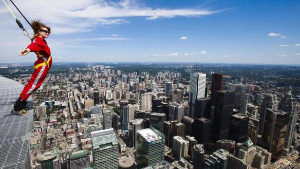 Edge Walk am CN Tower, Toronto, Kanada Der CN Tower in Toronto ist ein 553Meter hoher Fernsehturm und Wahrzeichen der Stadt. Auf dem Sims oberhalb des Drehrestaurants im Turmkorb befindet sich der EdgeWalk.