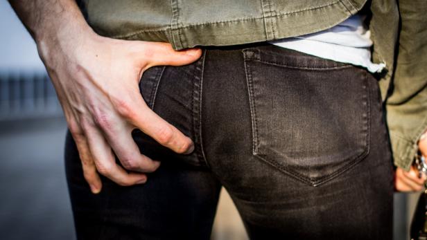 Groping Hand grabs woman's butt in public and harassing her