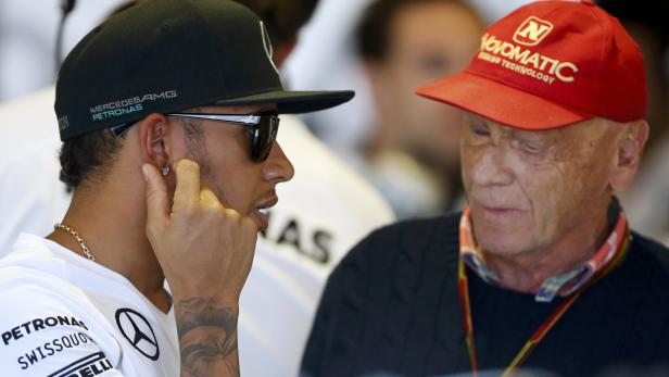Mercedes Formula One driver Hamilton of Britain speaks to former Formula One driver Lauda of Austria during the first practice session of the Australian F1 Grand Prix in Melbourne
