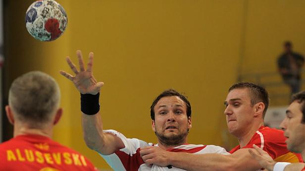 epa03256445 Austrian player Viktor Szilagyi (C) is tackled by FYR Macedonia player Stevche Alushovski (L) during the handball world championship qualification play-off match between between FYR Macedonia and Austria in Skopje, The Former Yugoslav Republic of Macedonia, 09 June 2012. EPA/NAKE BATEV