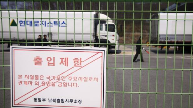 A South Korean security guard and truck drivers walk past trucks turning back to South Korea&#039;s CIQ (Customs, Immigration and Quarantine) after they were banned from entering the Kaesong industrial complex in North Korea, just south of the demilitarised zone separating the two Koreas, in Paju, north of Seoul, April 3, 2013. North Korean authorities were not allowing any South Korean workers into a joint industrial park on Wednesday, South Korea&#039;s Unification Ministry and a Reuters witness said, adding to tensions between the two countries. The sign reads &quot;limited access authorization&quot;. REUTERS/Kim Hong-Ji (SOUTH KOREA - Tags: MILITARY POLITICS TRANSPORT BUSINESS)