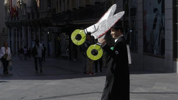 A protestor carries fake scissors during a funeral march for the public education in central Madrid September 29, 2011. Demonstrators in Madrid protest against an increase in weekly teaching hours -- and a reduction in class preparation time -- which they say will damage the quality of education and mean lost work for support teachers. REUTERS/Andrea Comas (SPAIN - Tags: CIVIL UNREST EDUCATION BUSINESS)