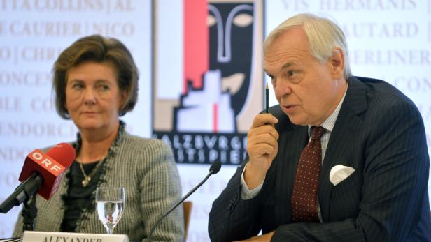 Eine Frau und ein Mann sitzen an einem Tisch mit Mikrofonen, im Hintergrund das Logo der Salzburger Festspiele.