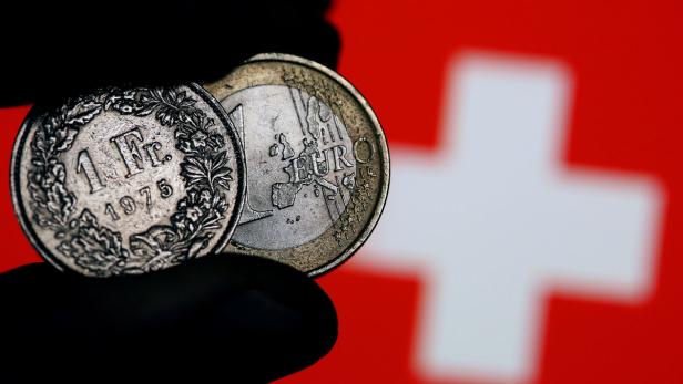 Euro-Münze und ein Schweizer Franken.