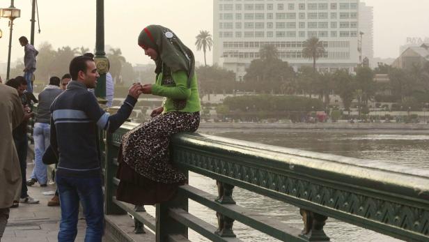 A couple talks on a bridge in central Cairo, February 13, 2012. Valentine&#039;s Day is celebrated across the world on February 14. REUTERS/Asmaa Waguih (EGYPT - Tags: SOCIETY)