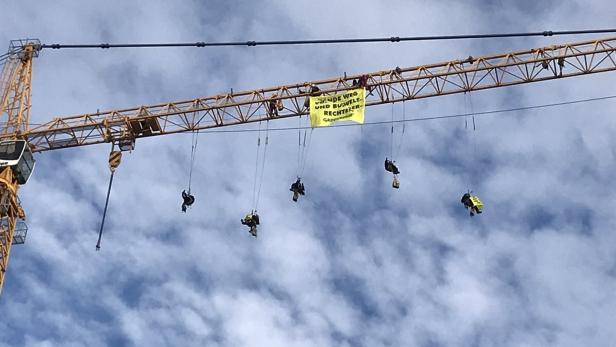 Greenpeace-Aktivisten kletterten auf einen Baukran beim Parlament.
