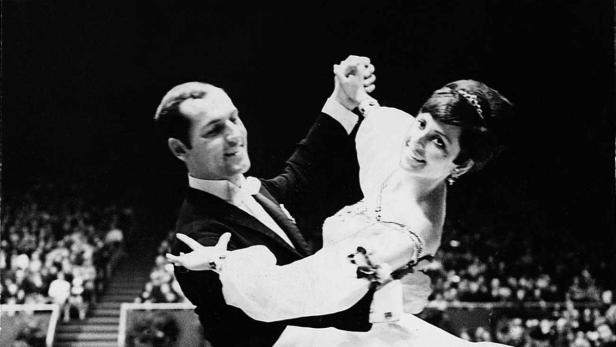 Ein Paar tanzt in einem Ballsaal vor einem Publikum.