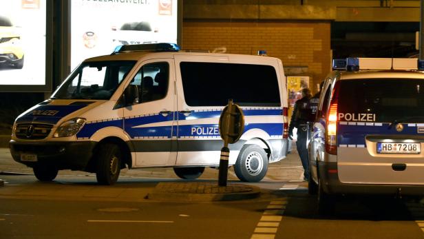 Zwei Mannschaftswagen der Polizei stehen nachts auf der Straße.