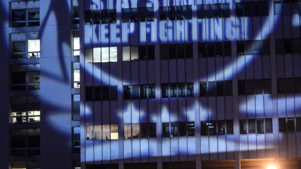 Auf ein Gebäude werden die Worte „45. Schumi. Stay strong! Keep fighting!“ projiziert.