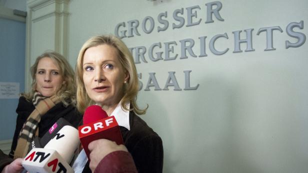 Eine blonde Frau spricht vor Mikrofonen im „Grosser Gerichtssaal“.