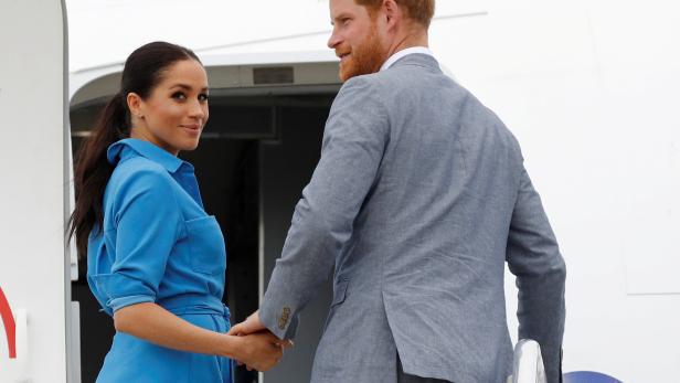 Britain's Prince Harry and Meghan, Duchess of Sussex look on before departing from Fua'amotu International Airport in Tonga