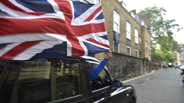 Ein Taxifahrer hält eine britische Flagge