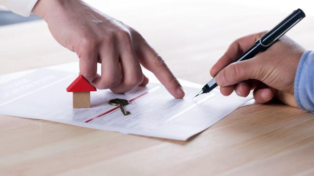 New homeowner signing contract of house sale or mortgage papers