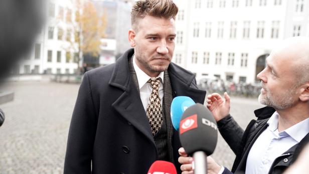 Denmark striker Nicklas Bendtner and lawyer Anders Nemeth speak to the media as they arrive at the Copenhagen City Council