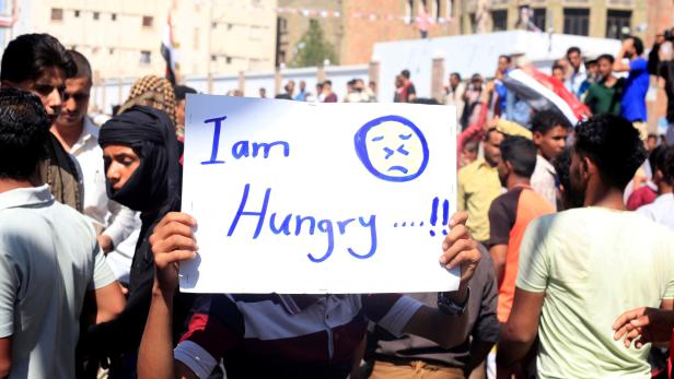 FILE PHOTO: Man holds a sign as he demonstrates against the deteriorating economy in Taiz