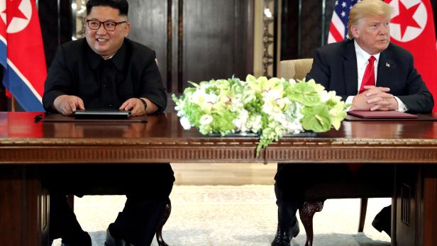 FILE PHOTO: U.S. President Trump and North Korea's Kim hold a signing ceremony at the conclusion of their summit in Singapore